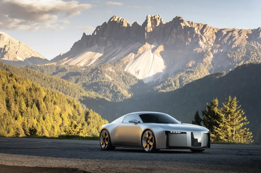 Voiture Audi de sport moderne sur fond de montagnes pittoresques et forêts verdoyantes.