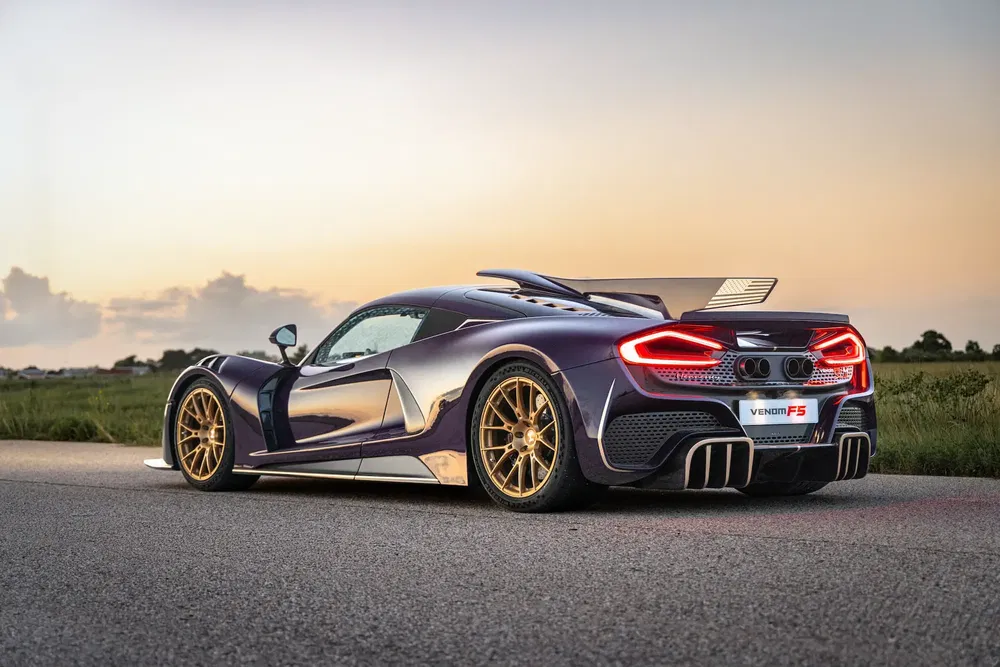 Hennessey Venom F5-auto bij zonsondergang op een afgelegen weg.