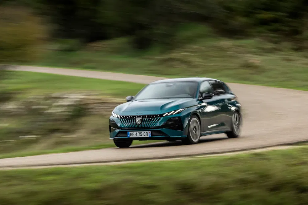 {"fr":"Peugeot 308 vert métallisé roulant rapidement sur une route de campagne sinueuse.","nl":"Groene Peugeot 308 die snel rijdt op een bochtige plattelandsweg."}
