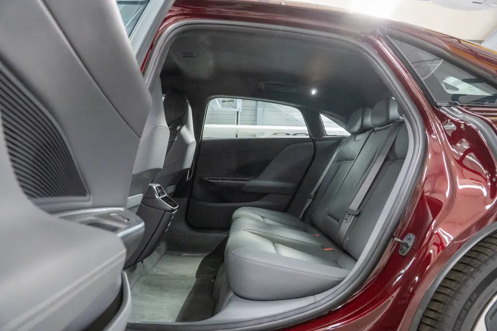 Intérieur arrière spacieux de voiture avec sièges en cuir gris et finition élégante.