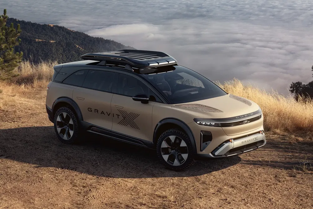 SUV Lucid Gravity beige stationné sur colline brumeuse avec toit panoramique.