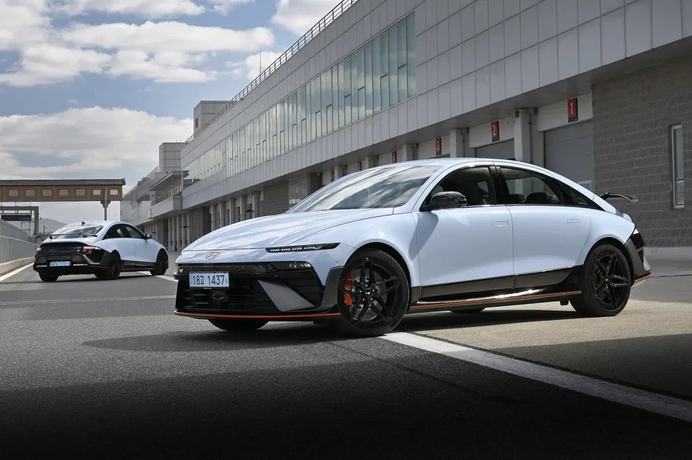 Deux Hyundai Ioniq 6 en piste, design sportif devant un bâtiment moderne.