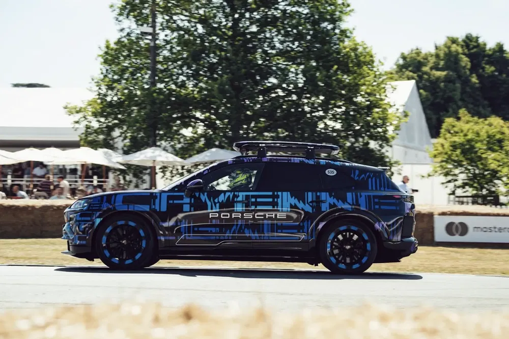 Porsche Cayenne customisé roulant en plein air lors d'un événement automobile.