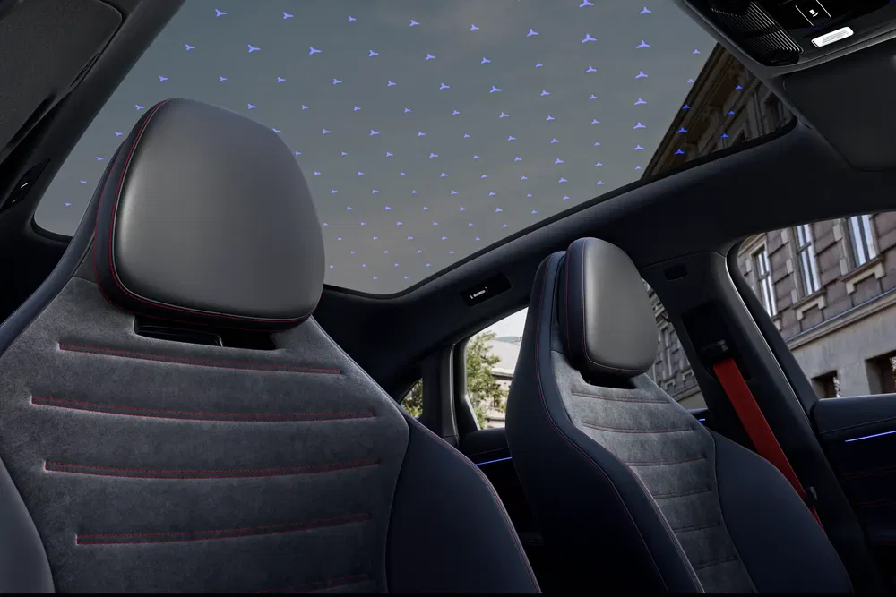 Intérieur d'une voiture avec toit en verre illuminé par des motifs de lumière bleue.