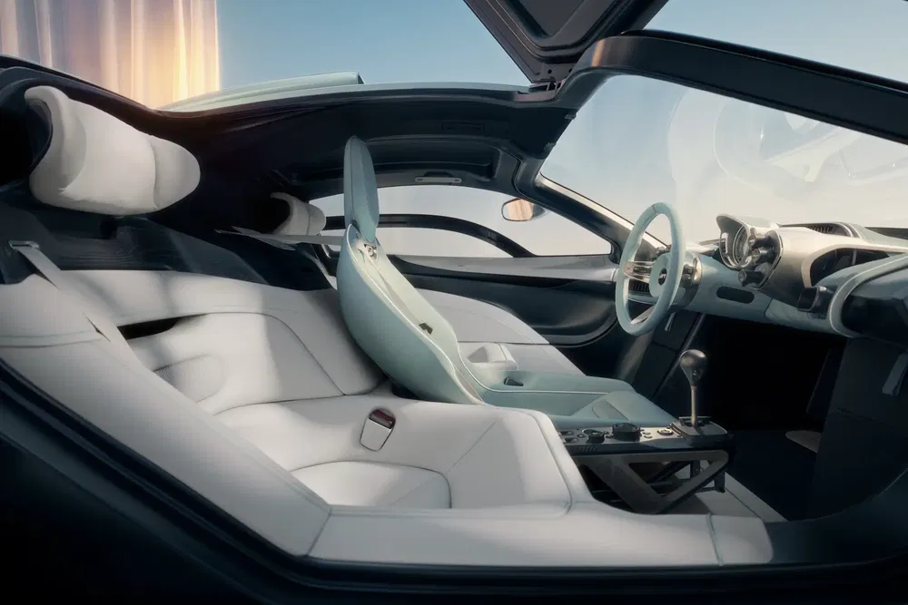 Intérieur futuriste d'une voiture électrique avec sièges blancs raffinés et tableau de bord moderne.