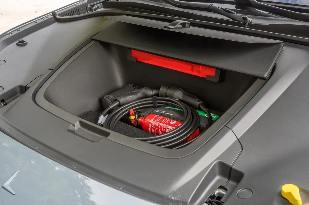 Coffre avant d'une voiture électrique Polestar avec câbles de recharge et extincteur.