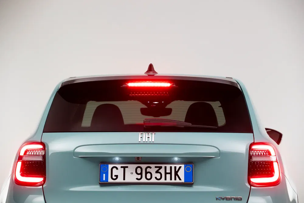 Achteraanzicht van een Fiat hybride met kenteken GT 963HK, achterlichten verlicht.