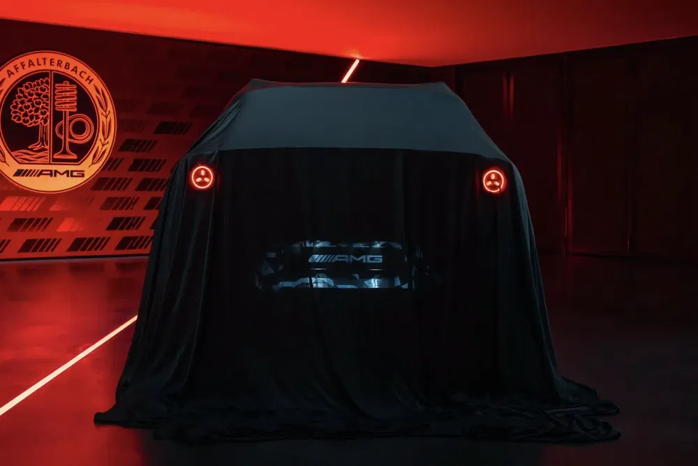 Mercedes-AMG auto onder doek, rood verlichte kamer, AMG-logo op de achtergrond.