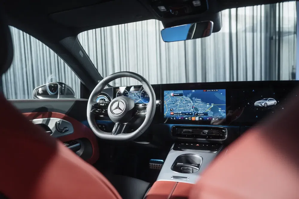 Intérieur Mercedes-Benz moderne avec tableau de bord numérique et volant en cuir.