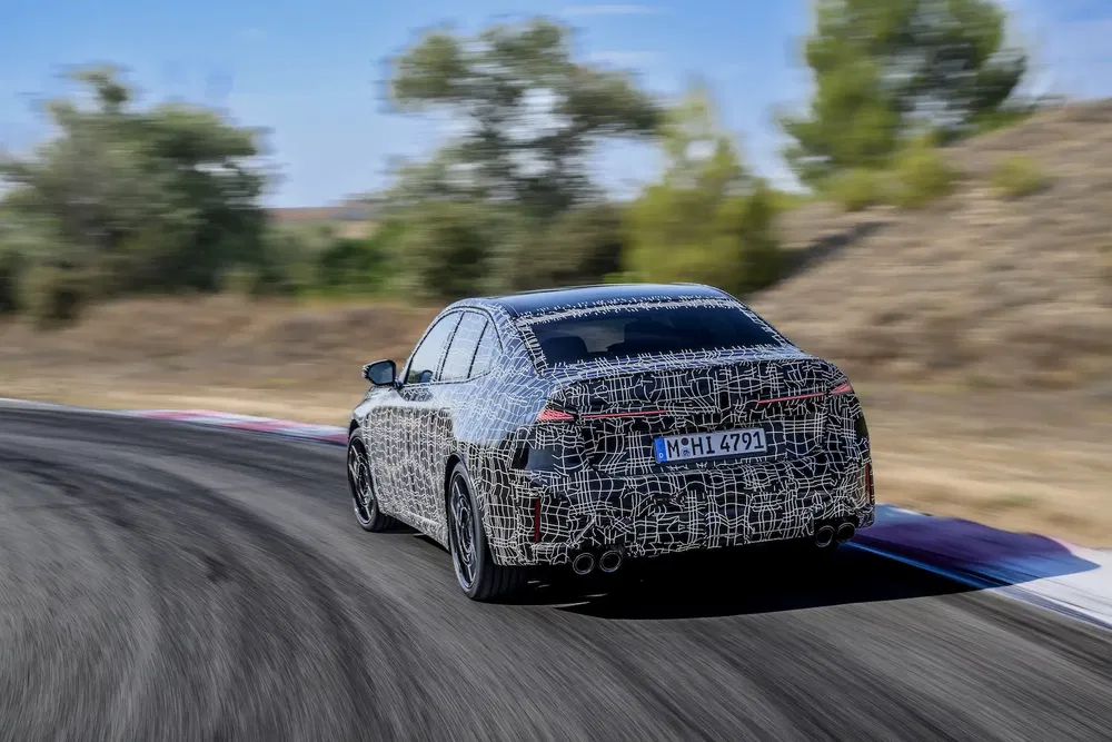 Prototype BMW série 5 camouflé testant sa conduite sur une piste sinueuse.