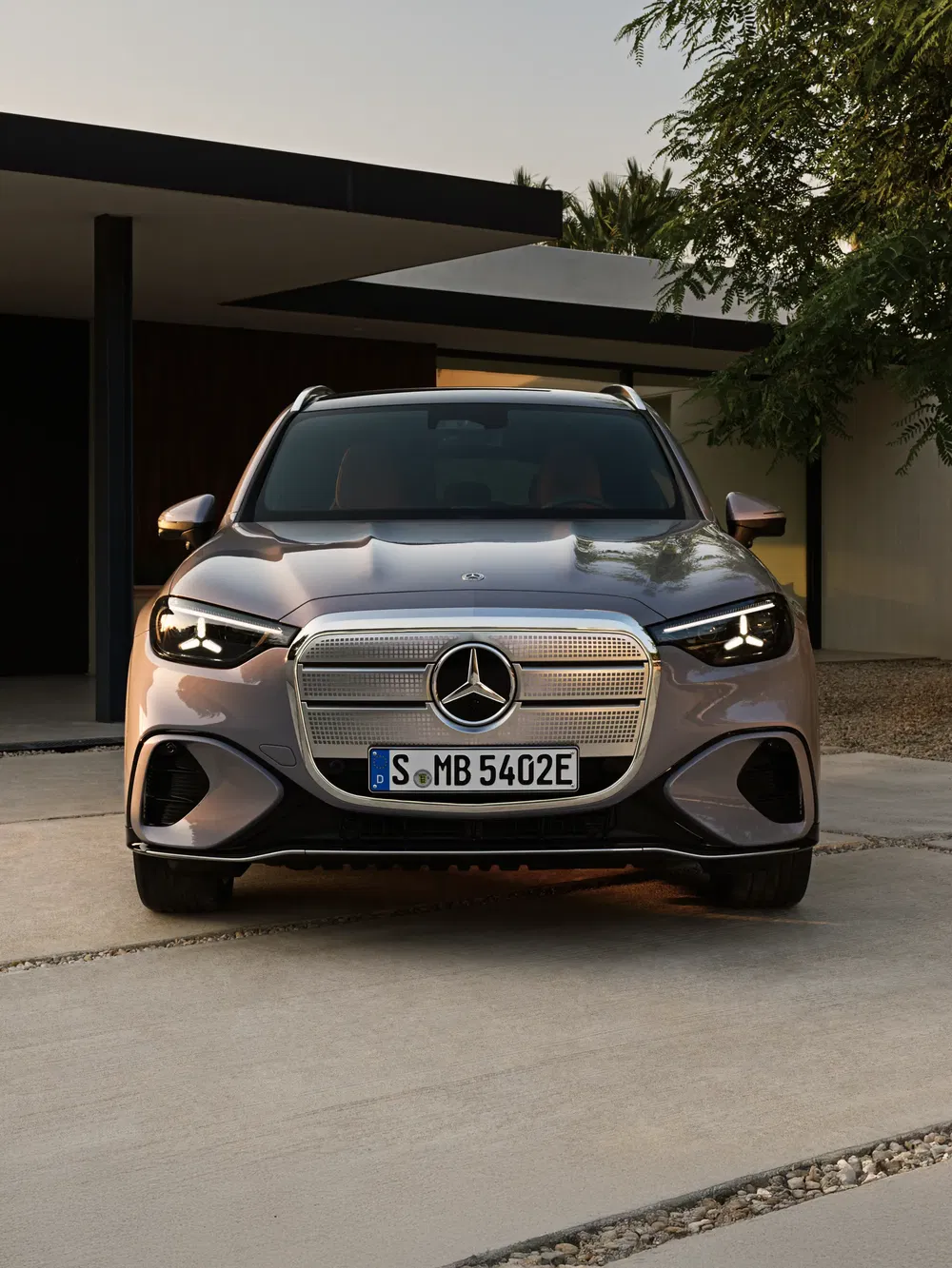 Grijze Mercedes-Benz EQB voor moderne woning, avondnatuurlijke verlichting.