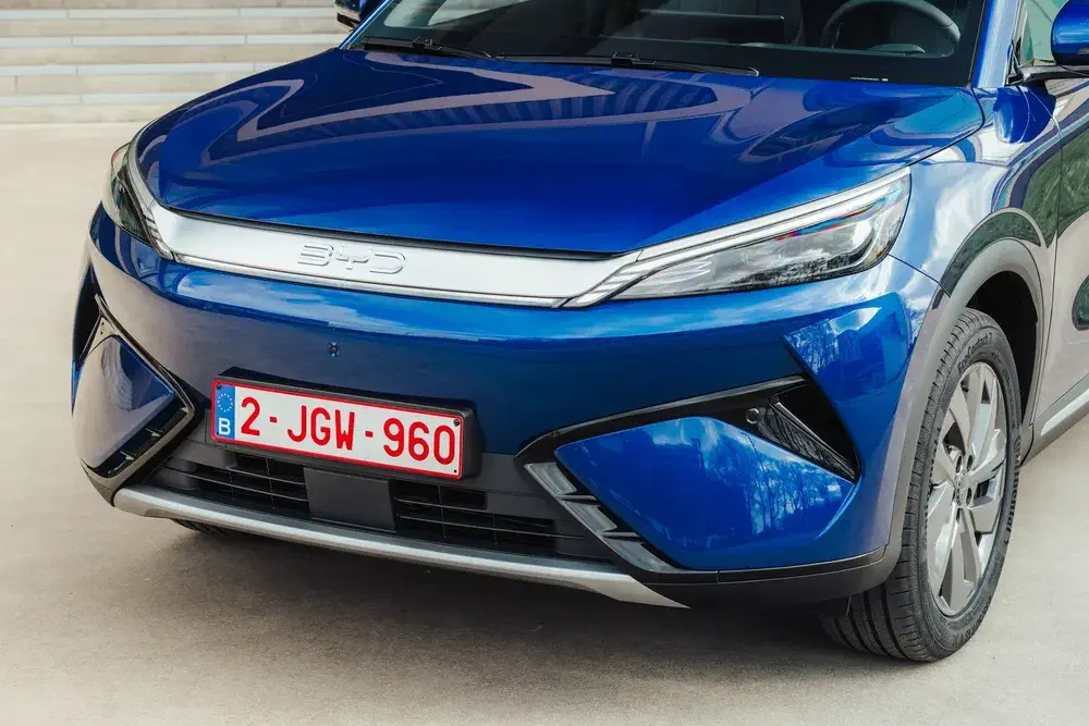 Voiture BYD bleu avec plaque belge, design avant moderne et dynamique.