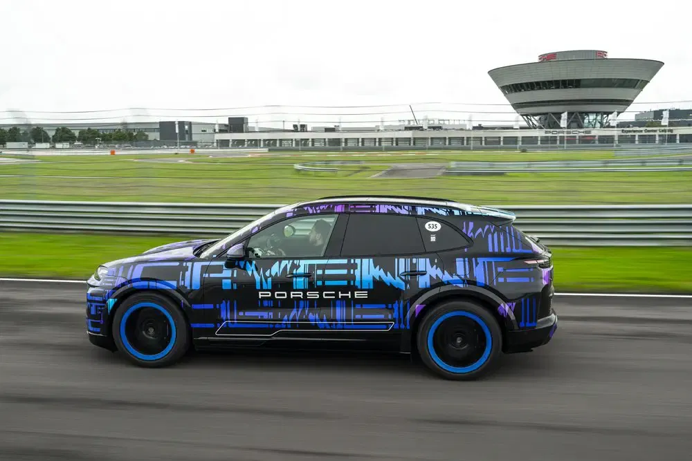 {"fr":"Porsche camouflée sur piste de course, design futuriste, bâtiments en arrière-plan.","nl":"Camouflage Porsche op racecircuit, futuristisch ontwerp, gebouwen op de achtergrond."}