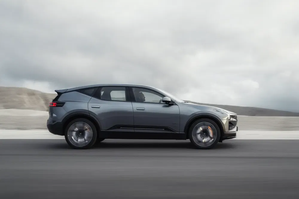 Elektrische luxeauto Fisker Ocean rijdt op een lege weg, met bewolkte lucht op de achtergrond.