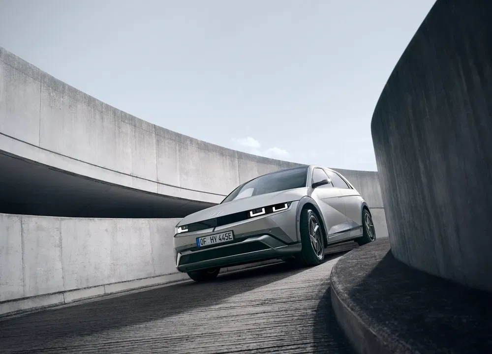 Hyundai Ioniq 5 grijs op een moderne, gebogen betonnen weg, futuristisch design.