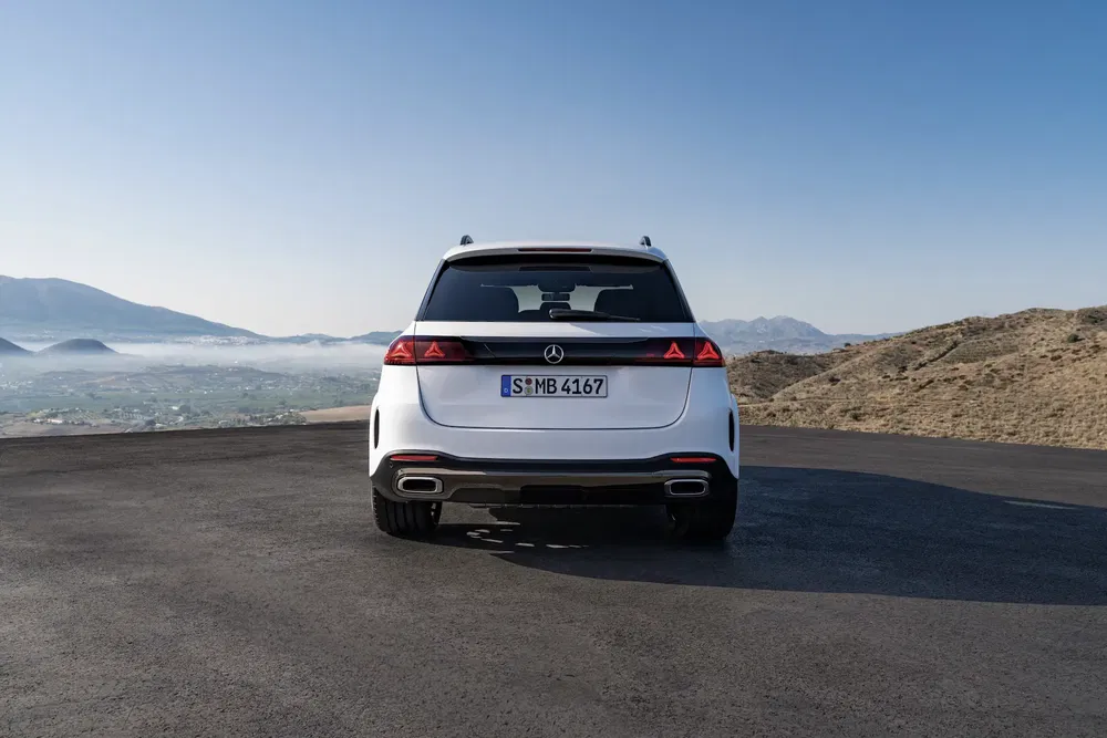 Mercedes-Benz GLE blanc vu de dos avec paysage montagneux en arrière-plan.