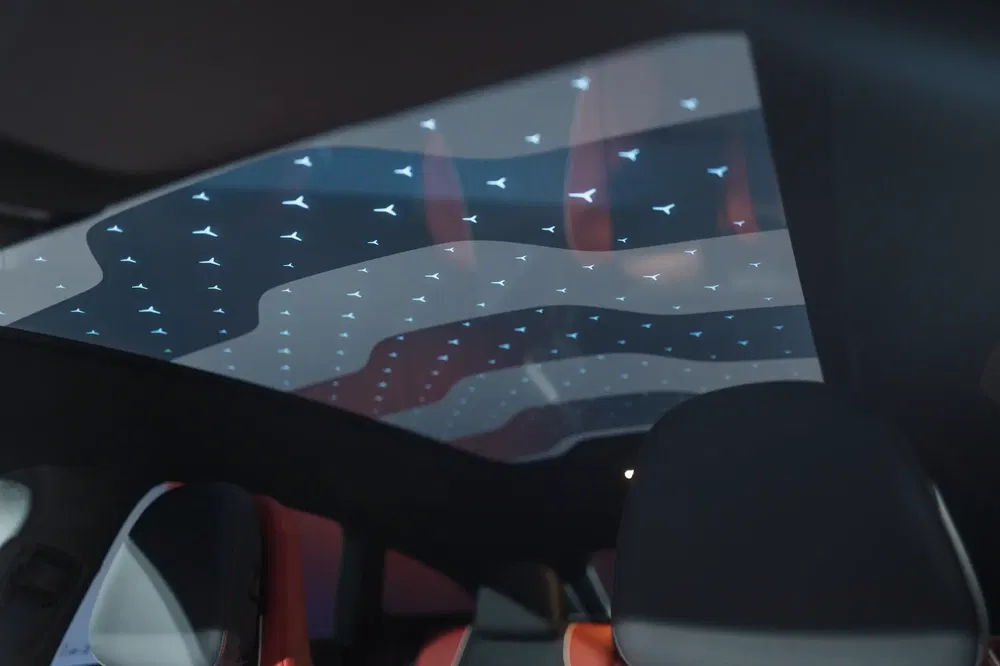 Vue intérieure avec toit panoramique éclairé de motifs lumineux dans une voiture moderne.
