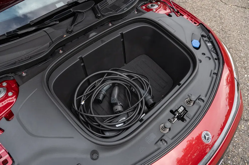 Coffre avant d'une Mercedes électrique avec câbles de recharge, couleur rouge.