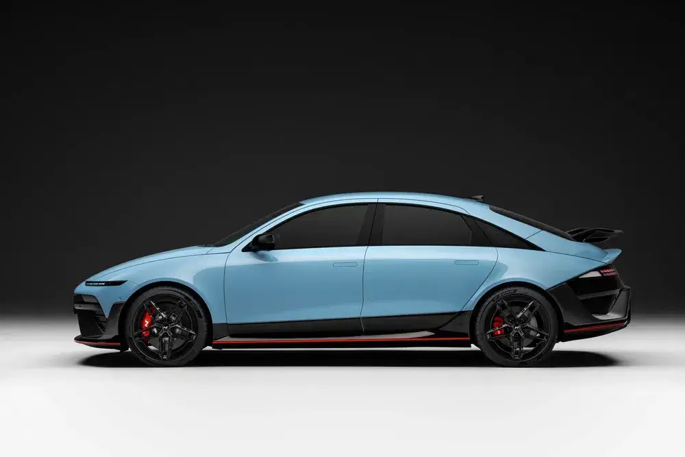 Lichtblauwe Hyundai Ioniq 6, gestroomlijnd ontwerp, zwarte sportvelgen, zwarte achtergrond.