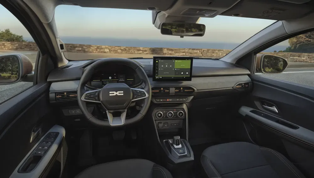 Intérieur moderne de voiture Dacia, écran tactile central, volant multifonctions, design épuré.