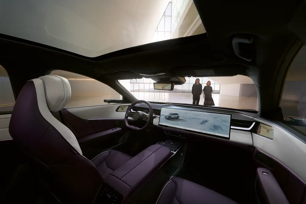 Intérieur d'une voiture électrique modernisée avec tableau de bord numérique et toit panoramique.