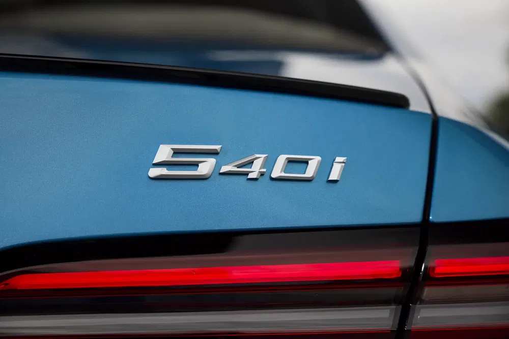 BMW 540i embleem op blauwe achterzijde met rode achterlichtstrip.