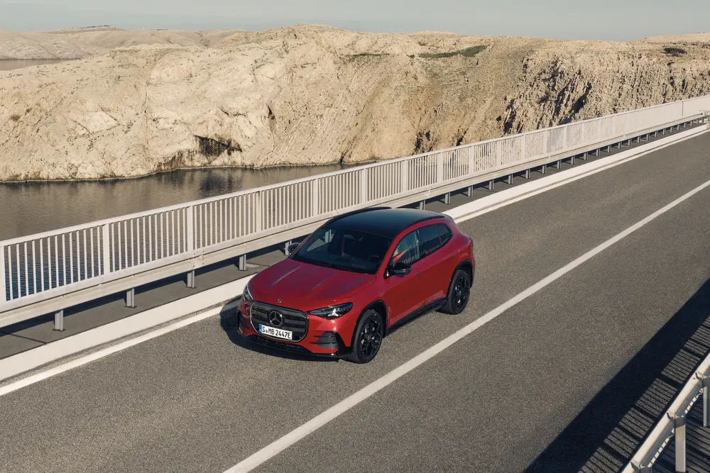 Rode Mercedes-Benz GLA rijdt over een brug in een rotsachtig landschap.