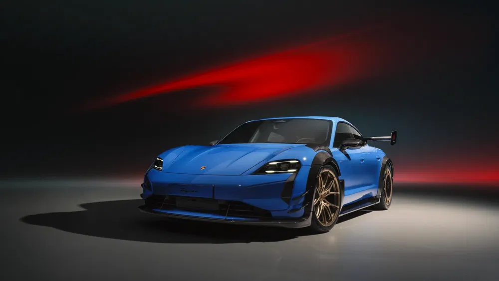 Porsche Taycan GT bleu électrique avec allure sportive sur fond sombre et rouge lumineux.