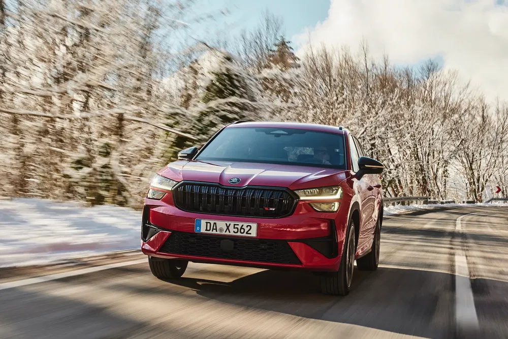 Skoda Kodiaq rouge sur route enneigée, hiver, design moderne, SUV performant.