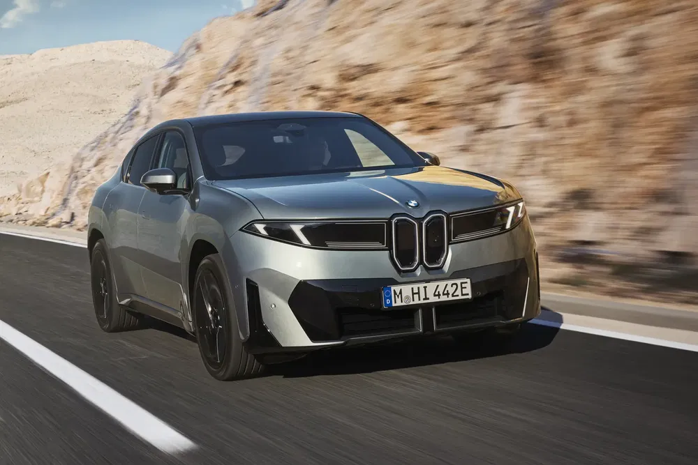 BMW électrique élégant sur route montagneuse, design futuriste et aérodynamique.