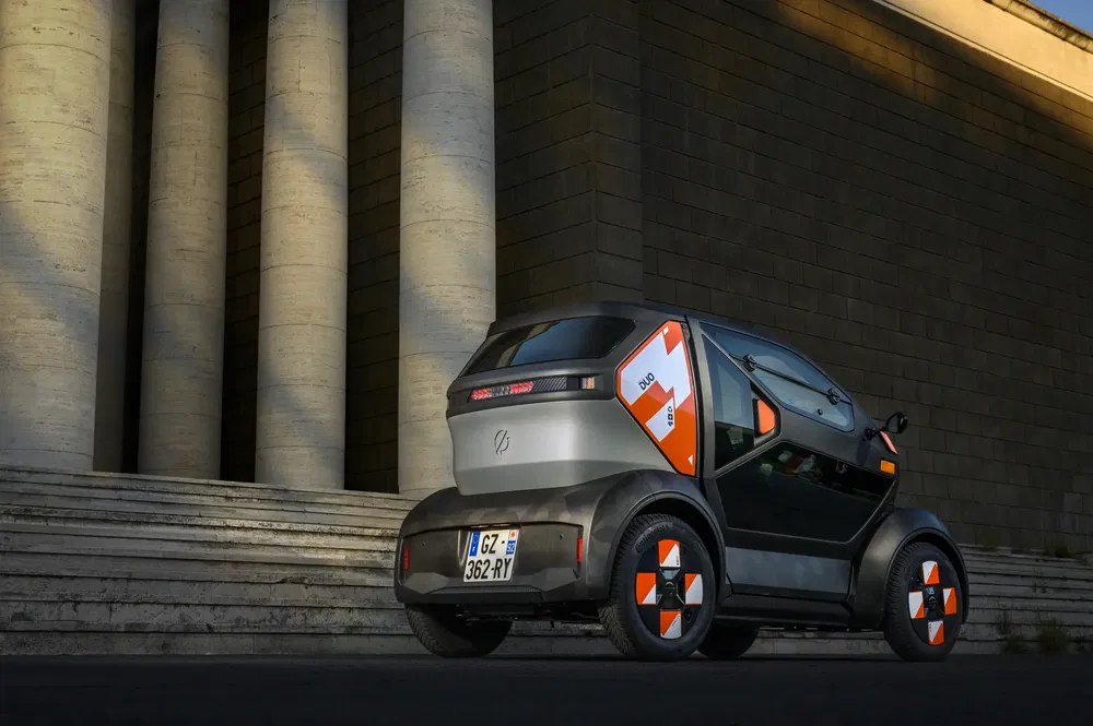 Voiture électrique optimisée pour la mobilité urbaine devant un bâtiment classique.