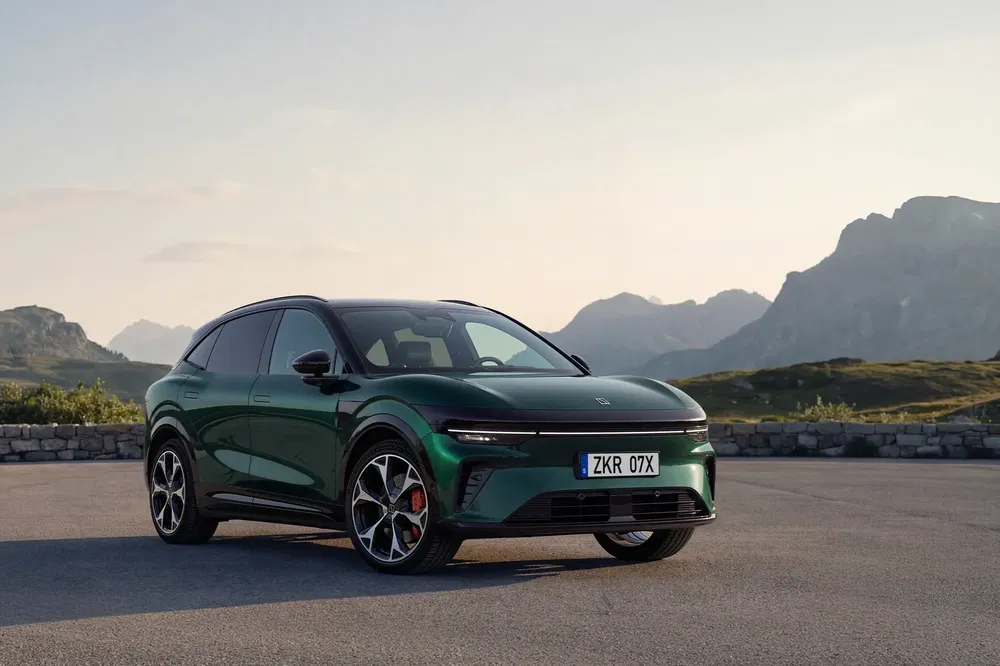 Voiture Polestar vert foncé garée sur une route de montagne avec un paysage pittoresque.