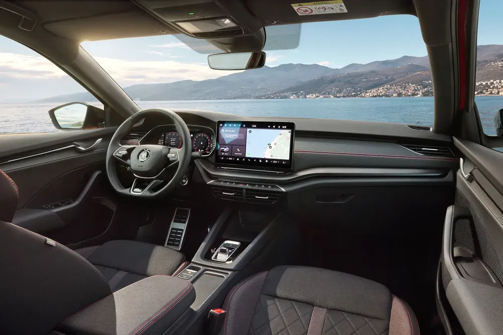 Intérieur de la Skoda Octavia avec écran tactile, vue sur mer, design moderne et élégant.