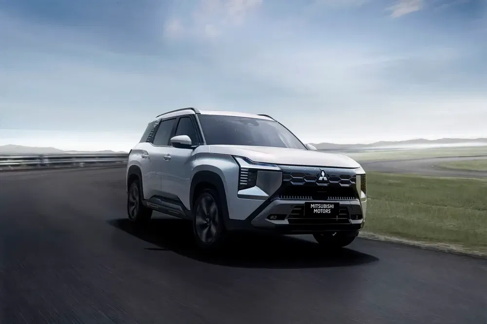 SUV Mitsubishi sur circuit, design avant-garde, ciel clair en arrière-plan.