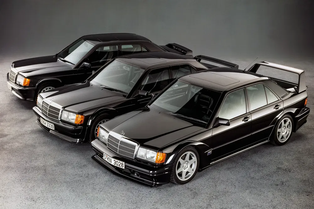 Trois Mercedes-Benz 190E Evolution II noires alignées, montrant leurs profils sportifs distinctifs.