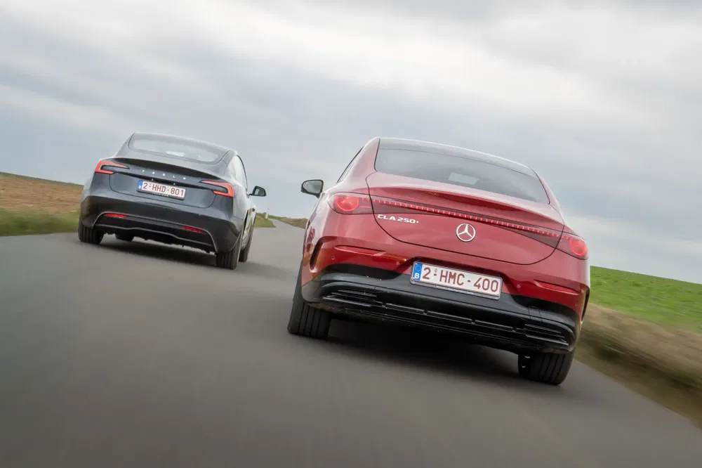 Deux voitures sur route de campagne, Mercedes CLA 250 rouge et véhicule gris.