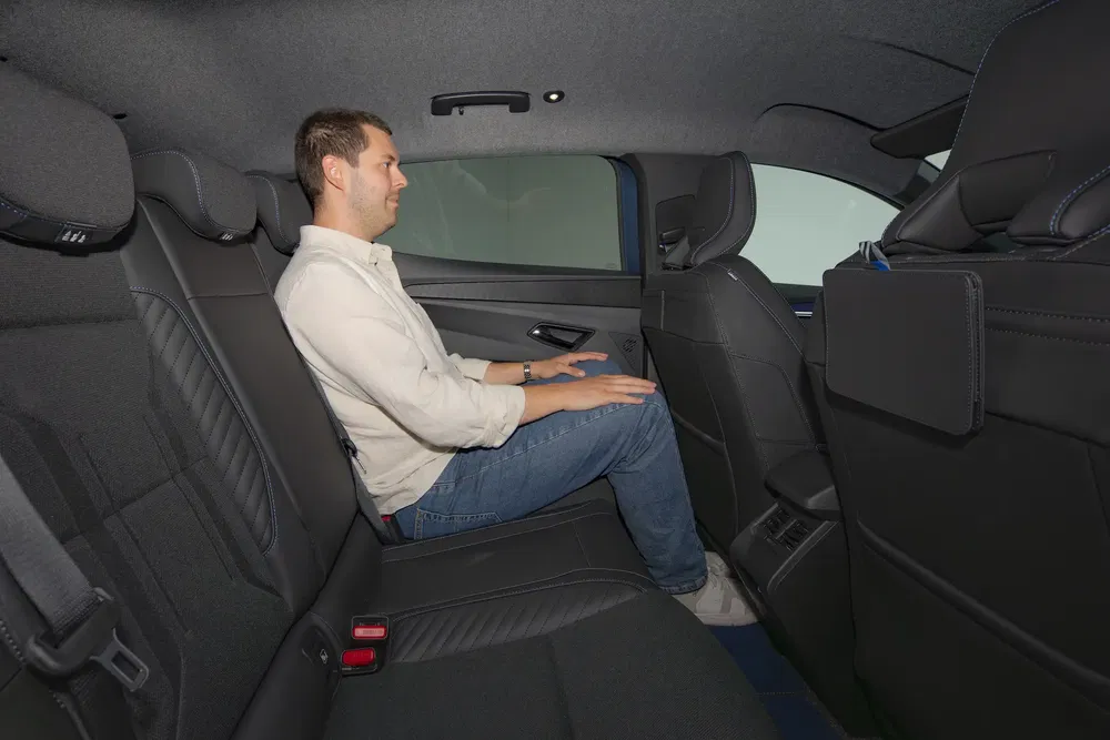 Homme assis dans l'espace arrière d'une BMW avec intérieur en tissu noir moderne.