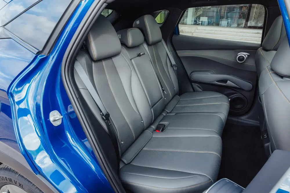 Achterinterieur van een MG elektrische auto, grijze lederen zetels, ruime zitplaats.