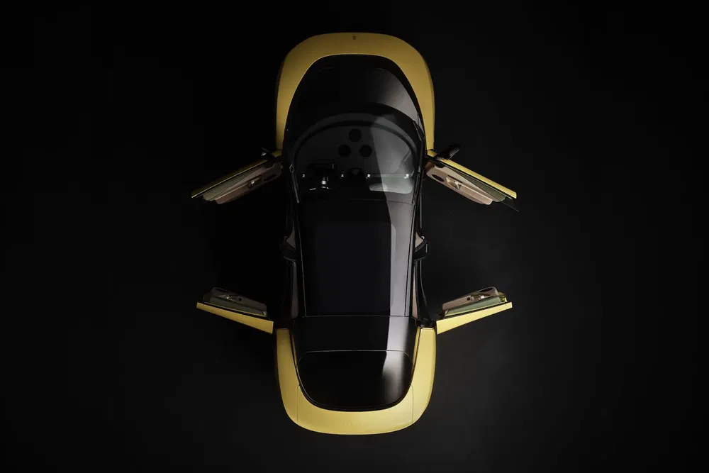 Vue aérienne d'une voiture noire et dorée avec portes ouvertes sur fond noir.