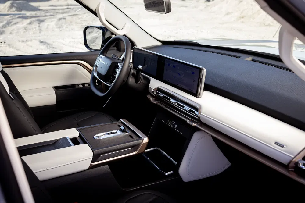 Intérieur moderne du GMC Sierra avec tableau de bord numérique et finitions en cuir blanc.
