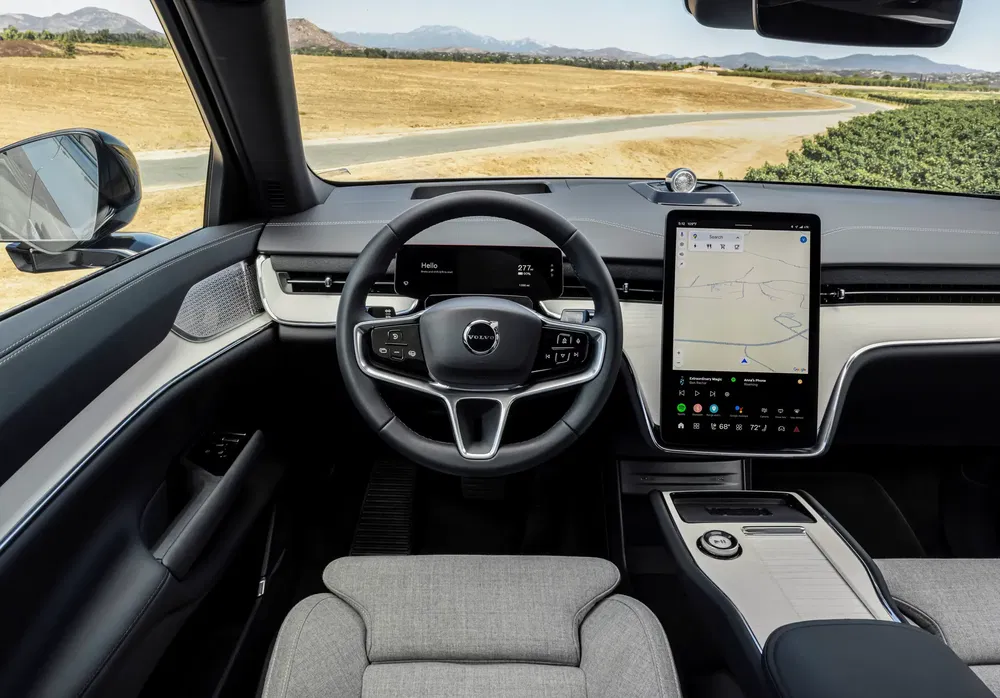 Moderne interieur van de Volvo EX90 met centraal touchscreen en stijlvolle stuurwiel.