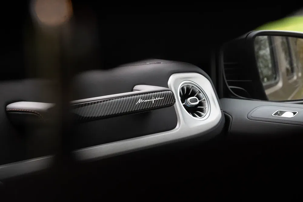 Intérieur de voiture Maserati avec tableau de bord en fibre de carbone et signature distinctive.