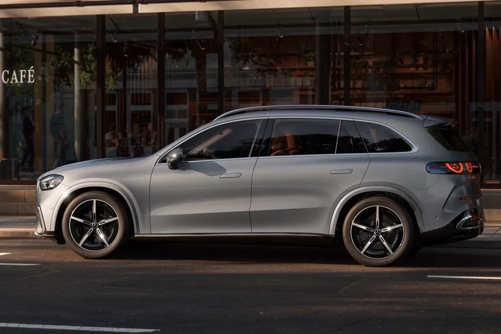 SUV Mercedes-Benz EQB argenté stationné devant un café urbain moderne.