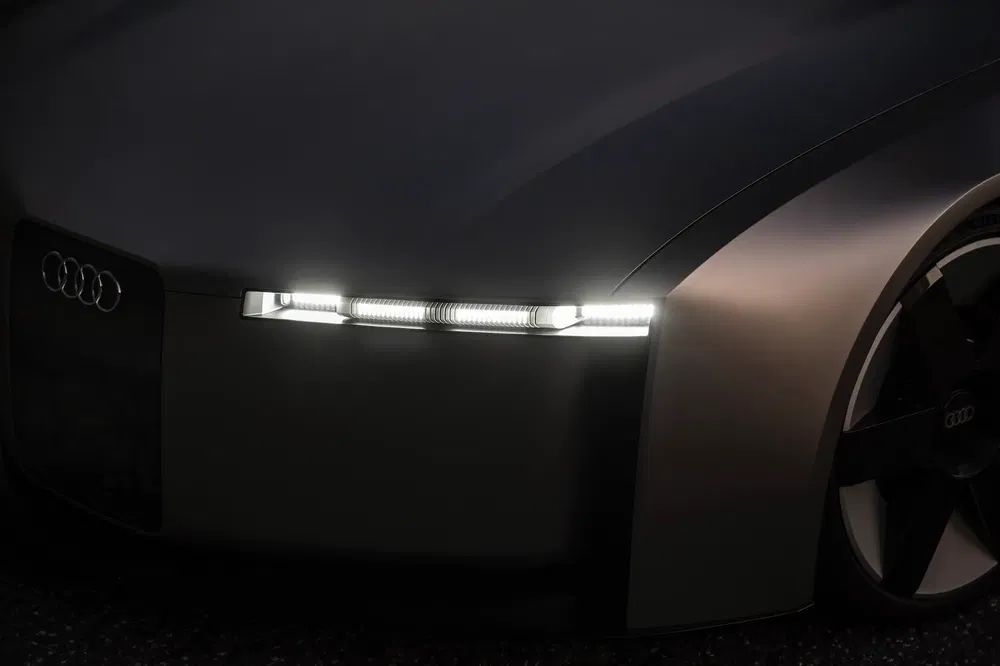 Gros plan des phares LED et logo Audi sur un concept-car moderne.