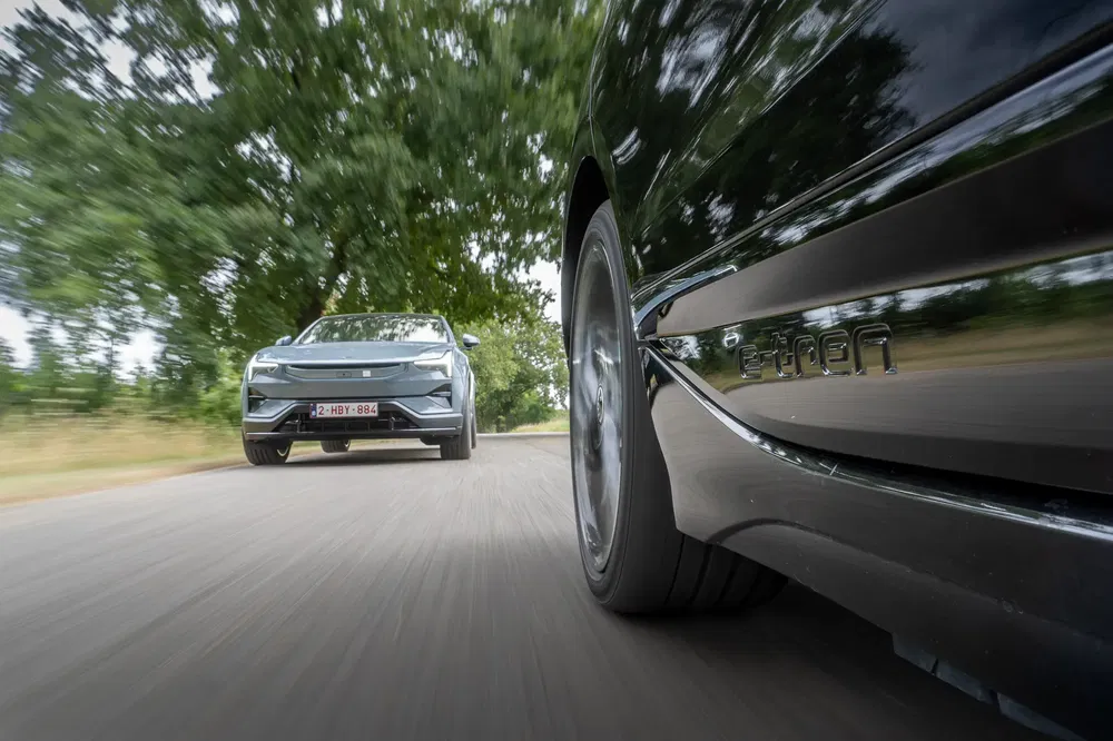 Course d'une voiture électrique et d'une Audi e-tron en pleine nature luxuriante.