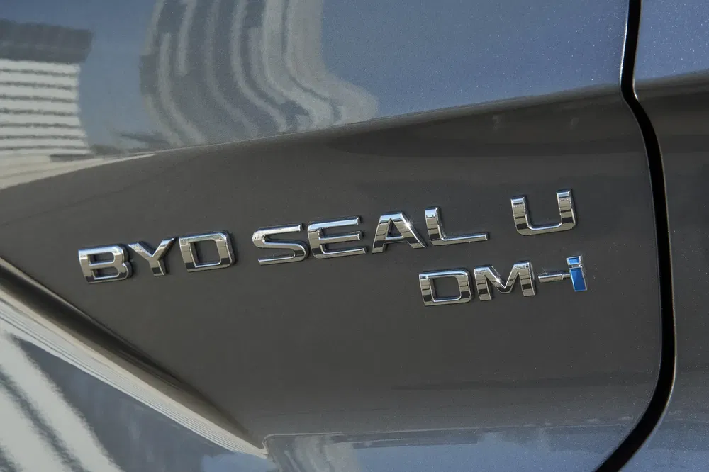 Logo du modèle BYD Seal U DM-i sur carrosserie grise.