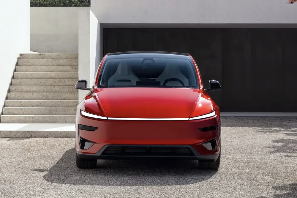 Rode elektrische auto voor een moderne woning met garage.