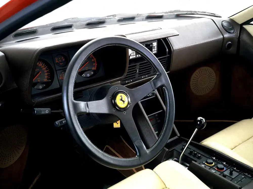 Klassiek Ferrari-interieur, iconisch stuurwiel en stijlvolle retro-dashboard.