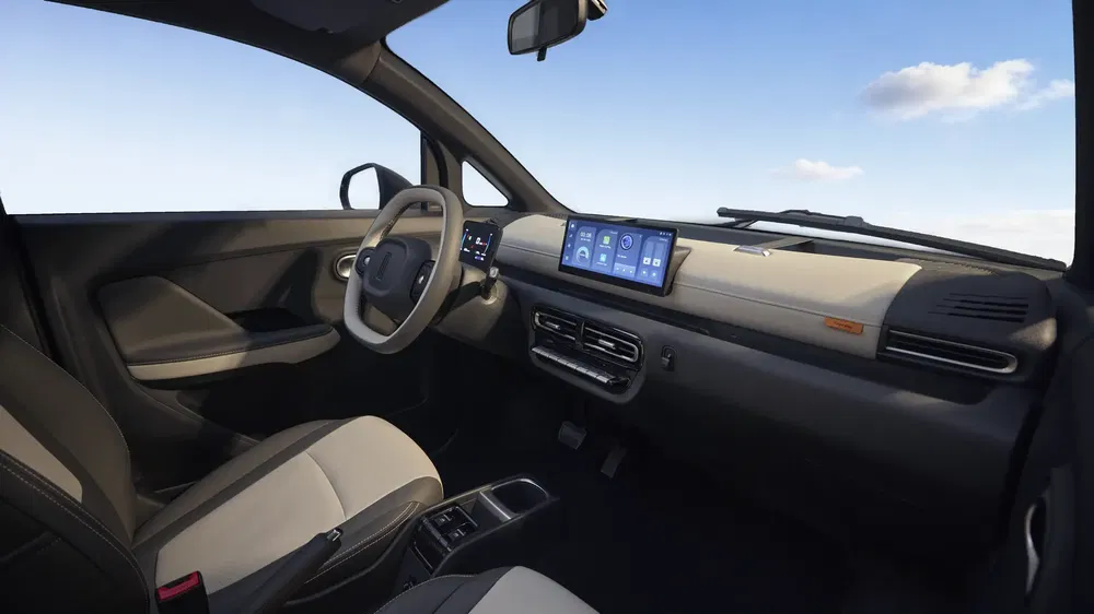 Intérieur de voiture moderne avec tableau de bord numérique, sièges en cuir et ciel bleu visible.