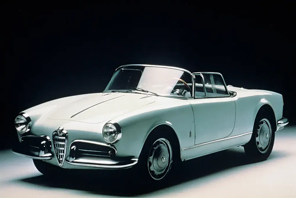 Voiture classique Alfa Romeo Giulietta Spider blanche en studio, design emblématique vintage.